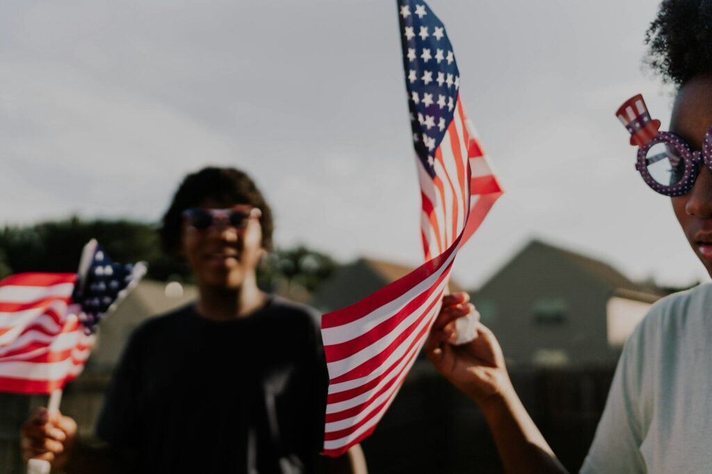 People celebrate with american flags and patriotic glasses