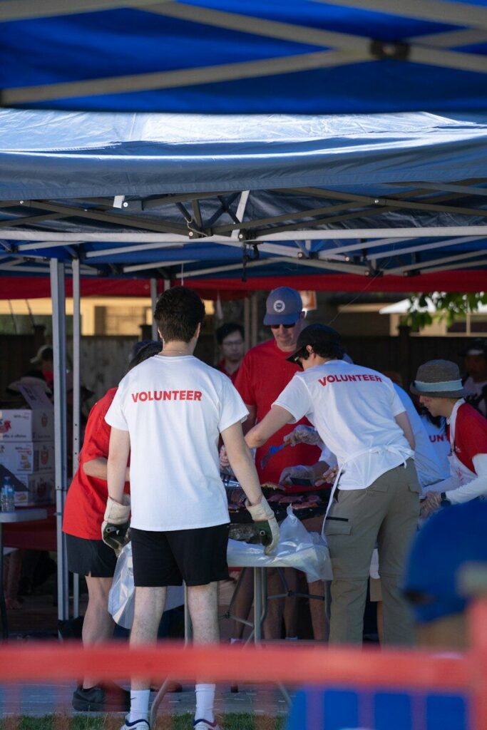 Volunteers organize items under a blue tent outdoors