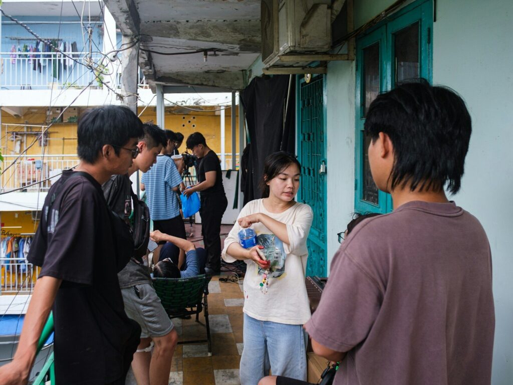 People gathered on a narrow balcony in an urban setting
